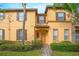 Two-story townhome with brown shutters and a brick walkway at 121 Palermo St, Davenport, FL 33897