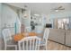 Dining area with round wooden table, white chairs, and kitchen view at 121 Palermo St, Davenport, FL 33897