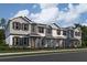 Three-story townhome with gray siding, white trim, and yellow front doors at 1340 Lumpini St, Saint Cloud, FL 34771