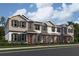 Three-story townhome with gray siding, white trim, and orange front doors at 1340 Lumpini St, Saint Cloud, FL 34771