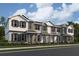 Three-story townhome with gray siding, white trim, and teal front doors at 1340 Lumpini St, Saint Cloud, FL 34771