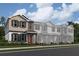 Three-story townhouses with gray and white siding, and orange doors at 1360 Lumpini St, St Cloud, FL 34771