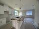 Open concept kitchen with island and white cabinets at 1360 Lumpini St, St Cloud, FL 34771