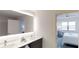 Modern bathroom with a double vanity, illuminated mirror, and walk-in shower at 14501 Grove Resort Ave # 2122, Winter Garden, FL 34787
