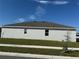 Rear view of a one-story home with a gray exterior and mature landscaping at 5231 Maddie Dr, Haines City, FL 33844