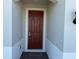 Covered entryway with a rich brown door and black and white welcome mat at 5231 Maddie Dr, Haines City, FL 33844