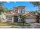 Two-story home with tan siding and a three-car garage at 7014 Phillips Cove Ct # 27, Orlando, FL 32819