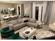 Open living room with gray sectional sofa, geometric rug, and large windows at 14739 Glade Hill Park Way, Winter Garden, FL 34787