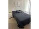 Guest bedroom with a queen-size bed, dark gray bedding, and wall decor at 14739 Glade Hill Park Way, Winter Garden, FL 34787