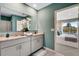 Bathroom with double vanity and view into bedroom at 1683 Three Bars Rd, Kissimmee, FL 34744