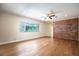 Living room with hardwood floors, large window, and brick accent wall at 2518 Sweetwater Trl, Winter Park, FL 32789