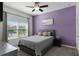 Bedroom with purple accent wall, gray bed, and plenty of natural light at 4285 Quote St, Kissimmee, FL 34746
