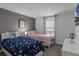Twin bedroom with gray and pink bedding and plenty of natural light at 4285 Quote St, Kissimmee, FL 34746