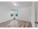 Well-lit bedroom with wood-look floors and two windows at 5353 White Blossom Cir, Saint Cloud, FL 34771