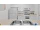 White kitchen with double sink and appliances at 8100 Princess Palm Ln # 305, Kissimmee, FL 34747