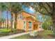 Two story yellow house with palm trees at 8447 Crystal Cove Loop, Kissimmee, FL 34747