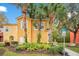 Two story yellow house with landscaping at 8447 Crystal Cove Loop, Kissimmee, FL 34747