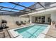 Private pool with covered patio, grill, and lounge chairs at 2412 Dubai St, Kissimmee, FL 34747