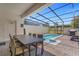 Private screened-in pool and patio area with outdoor dining table at 2412 Dubai St, Kissimmee, FL 34747