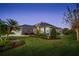 Single-story home with metal roof, landscaping, and a paved patio at dusk at 4040 Palma Ceia Cir, Winter Haven, FL 33884