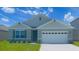 Two-story house with gray siding and two-car garage at 1010 Tupelo Trl, Haines City, FL 33844
