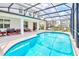 Inviting screened pool area with patio furniture and a view of neighboring homes at 2610 Calistoga Ave, Kissimmee, FL 34741