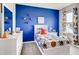 Youth bedroom with blue walls and sports-themed bedding at 3475 Sandalwood Isle Way, Ocoee, FL 34761