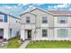 Two-story townhome with gray siding, shutters, and a landscaped front yard at 3894 Lana Ave, Davenport, FL 33897