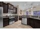 Open concept kitchen with island, stainless steel appliances, and dark cabinets at 4001 Scarlet Branch Rd, Orlando, FL 32824