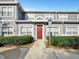 Gray townhome with red door, white picket fence, and landscaping at 4560 Spigold Court # 104, Kissimmee, FL 34746