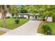 Mid-century modern home with a paved driveway and lush landscaping at 627 Carvell Dr, Winter Park, FL 32792