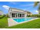 Two-story home featuring a refreshing pool, expansive patio, and lush lawn at 7736 Graben St, Kissimmee, FL 34747