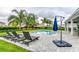 Relaxing pool area with lounge chairs and patio umbrella at 7736 Graben St, Kissimmee, FL 34747