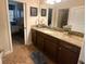 Bathroom with granite countertop, dark brown cabinets, and a view into the bedroom at 9030 Shadow Mountain St, Davenport, FL 33896