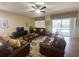 Living area with pool view, leather sofas, and a large window at 9030 Shadow Mountain St, Davenport, FL 33896