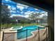Screened pool and spa with patio seating area at 9030 Shadow Mountain St, Davenport, FL 33896