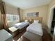 Well-lit bedroom with two twin beds, nightstands, and large window at 3131 Brasilia Ave, Kissimmee, FL 34747
