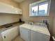 Laundry room with washer, dryer, sink, and upper cabinets at 3131 Brasilia Ave, Kissimmee, FL 34747