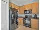 Well-equipped kitchen featuring black appliances and wood cabinets at 480 Scarlatti Ct, Ocoee, FL 34761