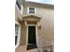 Townhouse entrance with a dark green door and white railing at 6462 Cantua Ln # 105, Orlando, FL 32835