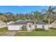 Single-story house with solar panels, light teal door and attached garage at 1053 E Hancock Dr, Deltona, FL 32725