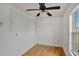 Empty spare bedroom features light wood floors, ceiling fan, and large window at 1053 E Hancock Dr, Deltona, FL 32725