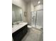 Bathroom with a shower and dark vanity at 1144 Challenge Dr, Davenport, FL 33896