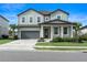 Two story house with gray siding, two car garage and manicured lawn at 2094 Derwent Dr, Davenport, FL 33896