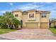 Two-story house with a three-car garage, paver driveway, and lush landscaping at 2760 Rialto Ct, Kissimmee, FL 34746