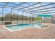 Screened pool area with lounge chairs and umbrella at 2760 Rialto Ct, Kissimmee, FL 34746