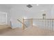 Upstairs hallway with neutral carpeting and iron railings at 2760 Rialto Ct, Kissimmee, FL 34746
