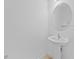 Small, clean powder room with pedestal sink and round mirror at 2760 Rialto Ct, Kissimmee, FL 34746