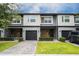 Modern two-story townhome with gray and wood siding, two-car garage, and landscaped lawn at 4410 Le Reve Ct, Kissimmee, FL 34746
