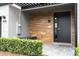 Front entry with modern wood-look tile and black door at 4410 Le Reve Ct, Kissimmee, FL 34746